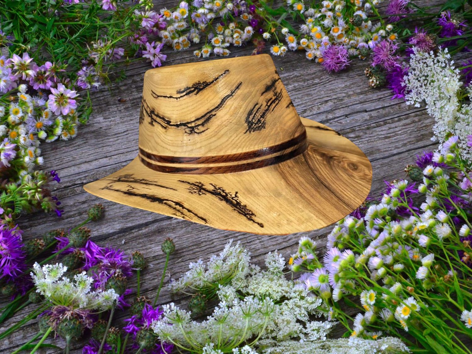 Holzhut mit Blumen auf Holzbrettern